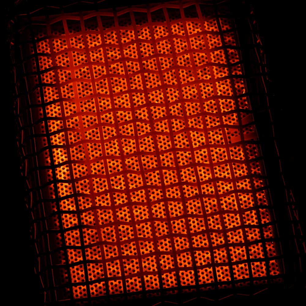 Infrared grill heating grid glowing orange under metal frame