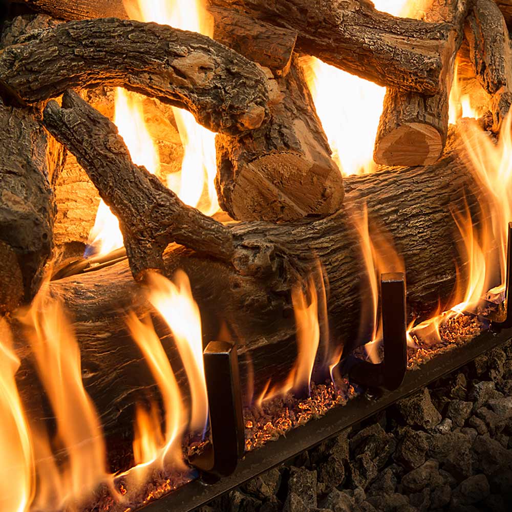 Weathered oak gas log set close-up with tall flame jets