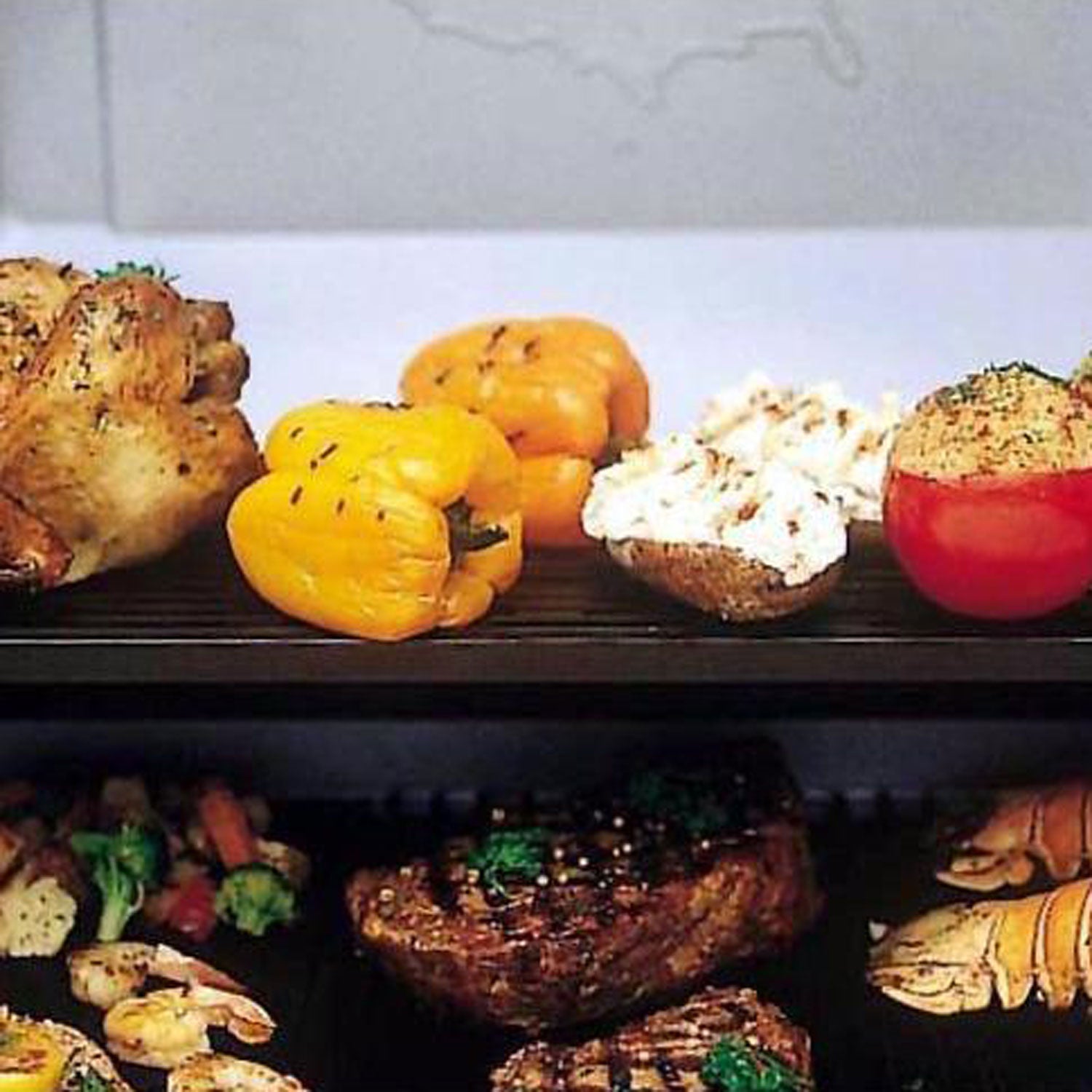 Grilled vegetables and meat on black grill grate