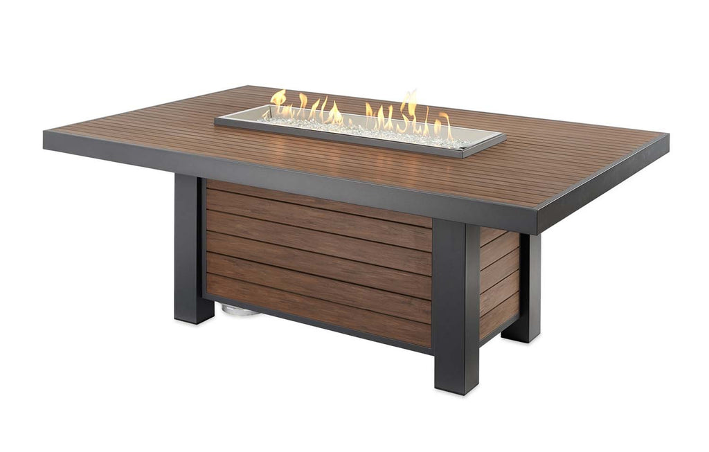 Gas fire pit table with dark legs, wood slat cabinet, and lit burner insert