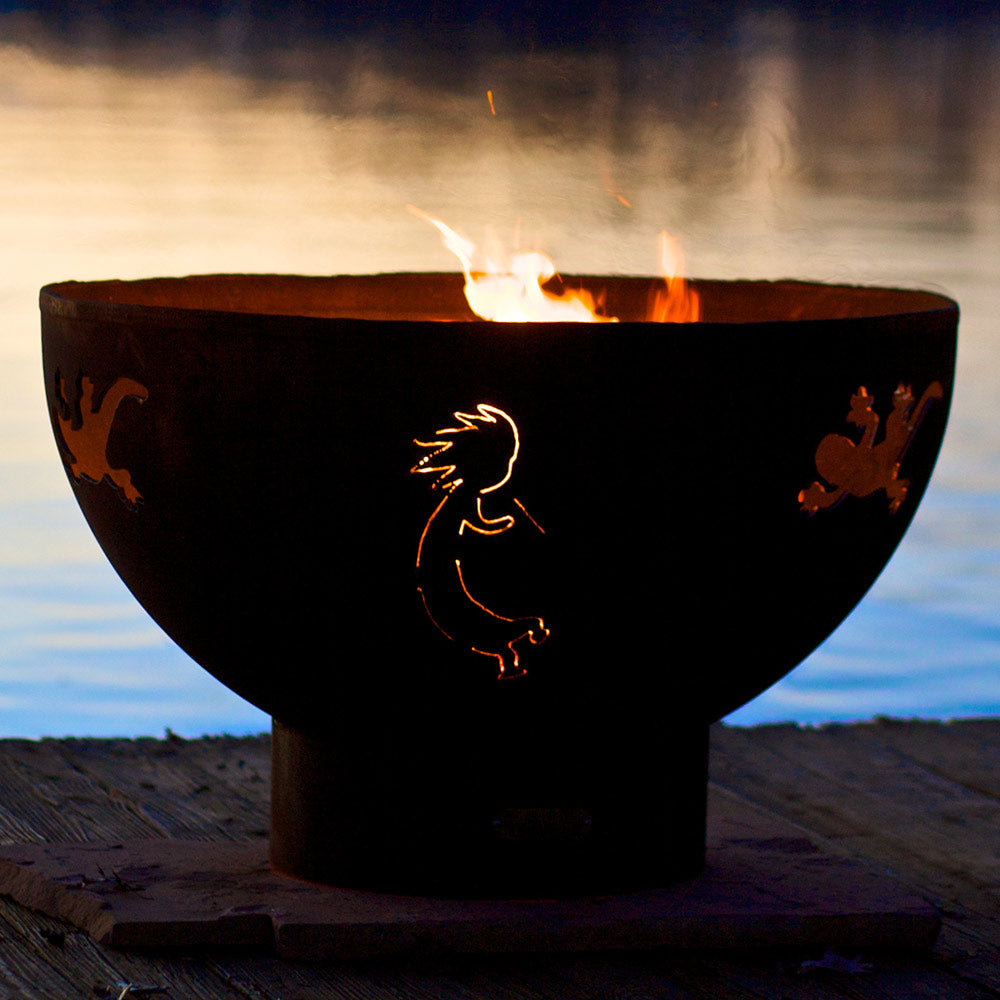 Black gas fire pit with lit Kokopelli design on bowl and flames