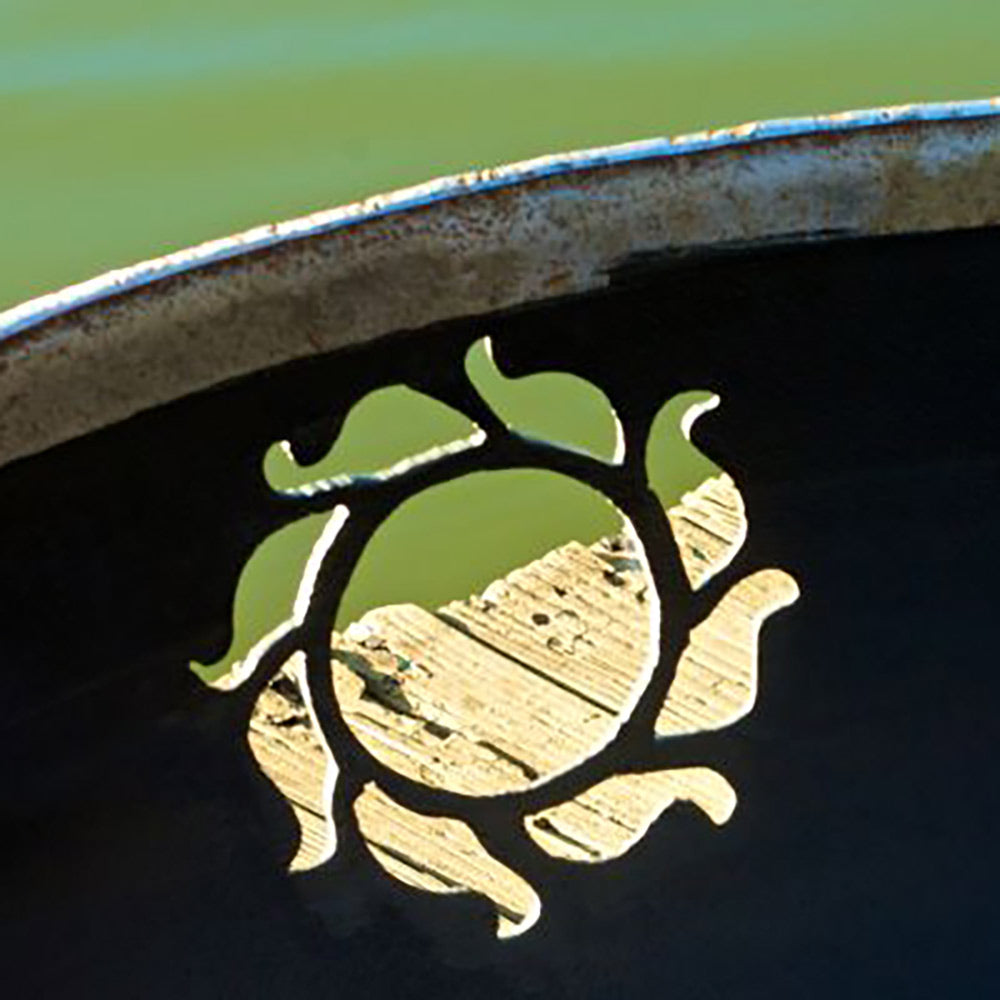 Metal cutout Kokopelli silhouette on fire pit bowl interior