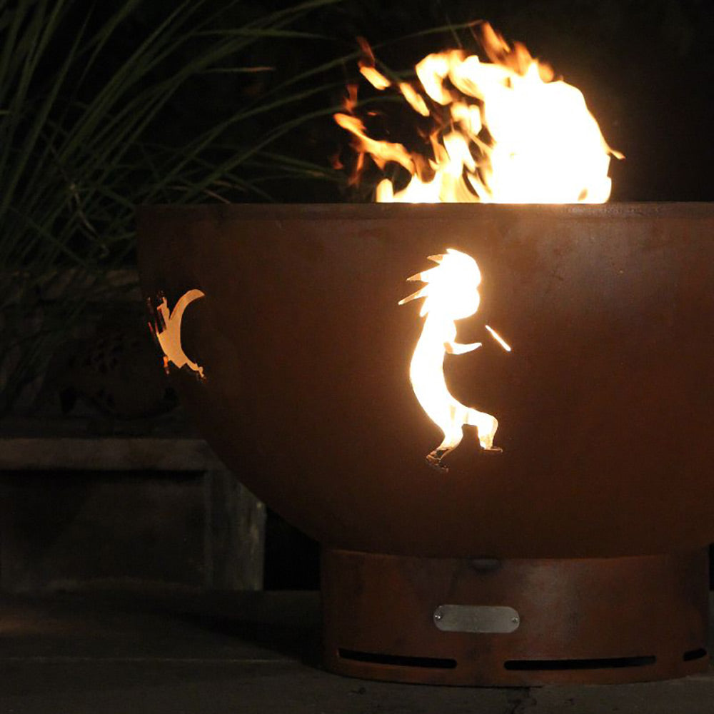 Brown gas fire pit with Kokopelli cutout, flames rising at night