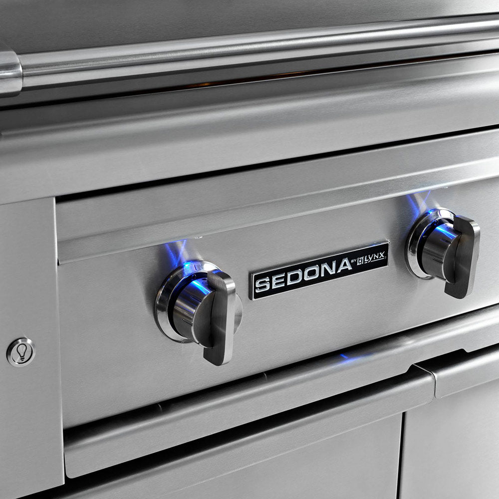 Stainless steel gas grill with 'Sedona' branding on control knobs.