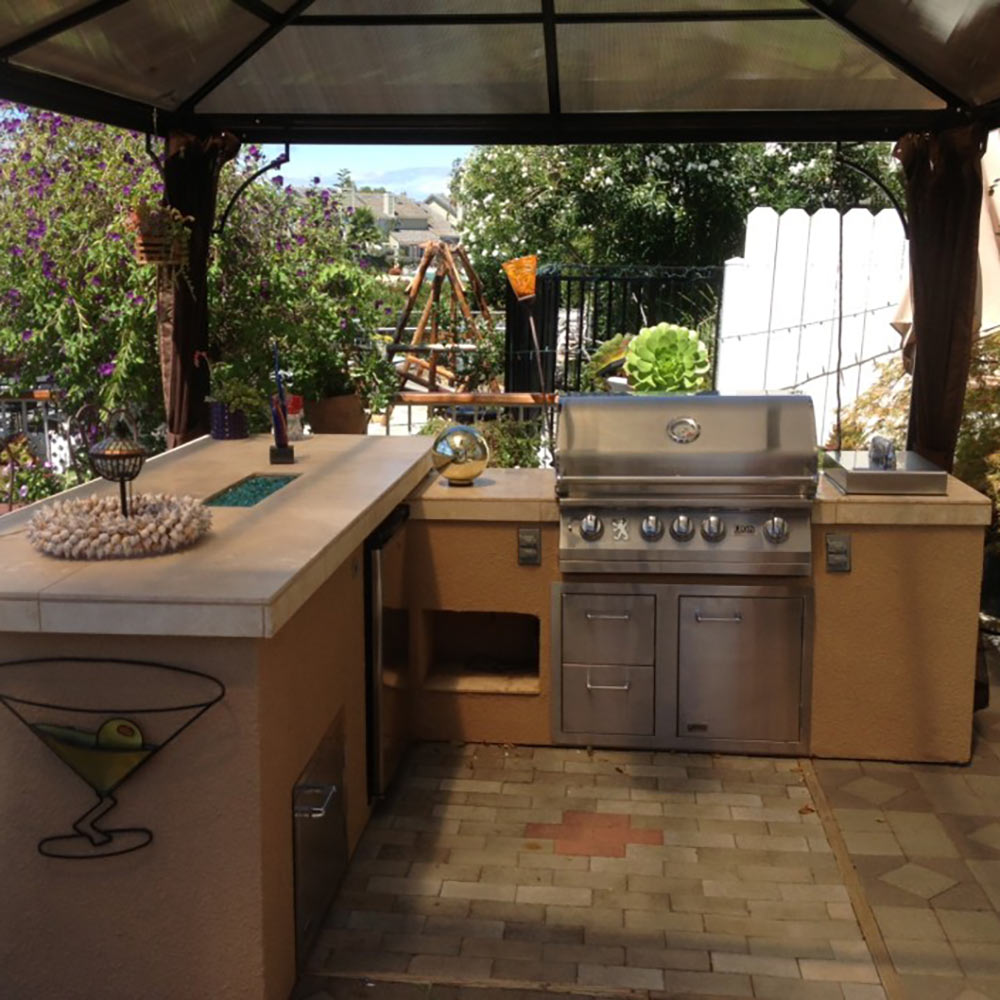 Built-in stainless steel gas grill with side controls in outdoor kitchen island