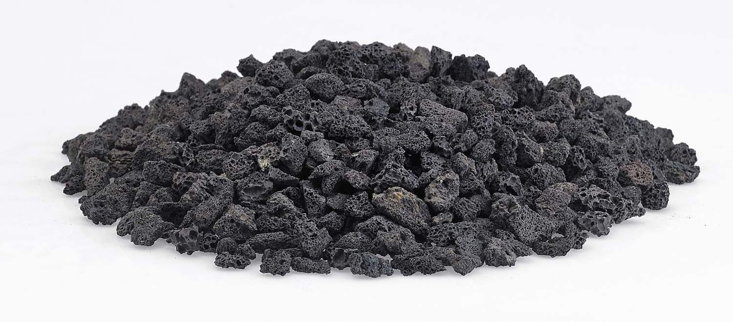 Small black lava rock stones spread out, rough porous texture
