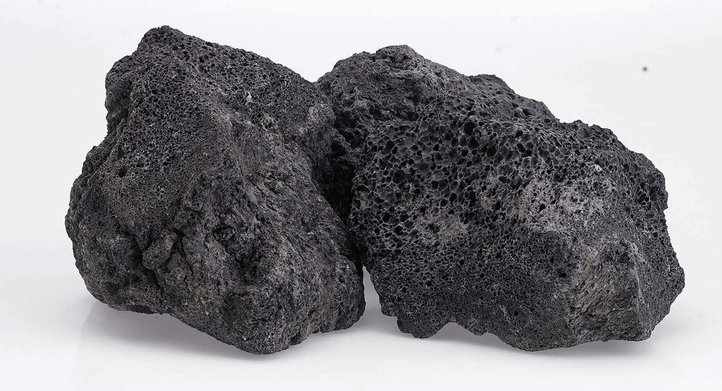 Black lava rock pieces with rugged porous faces, stacked in a small group