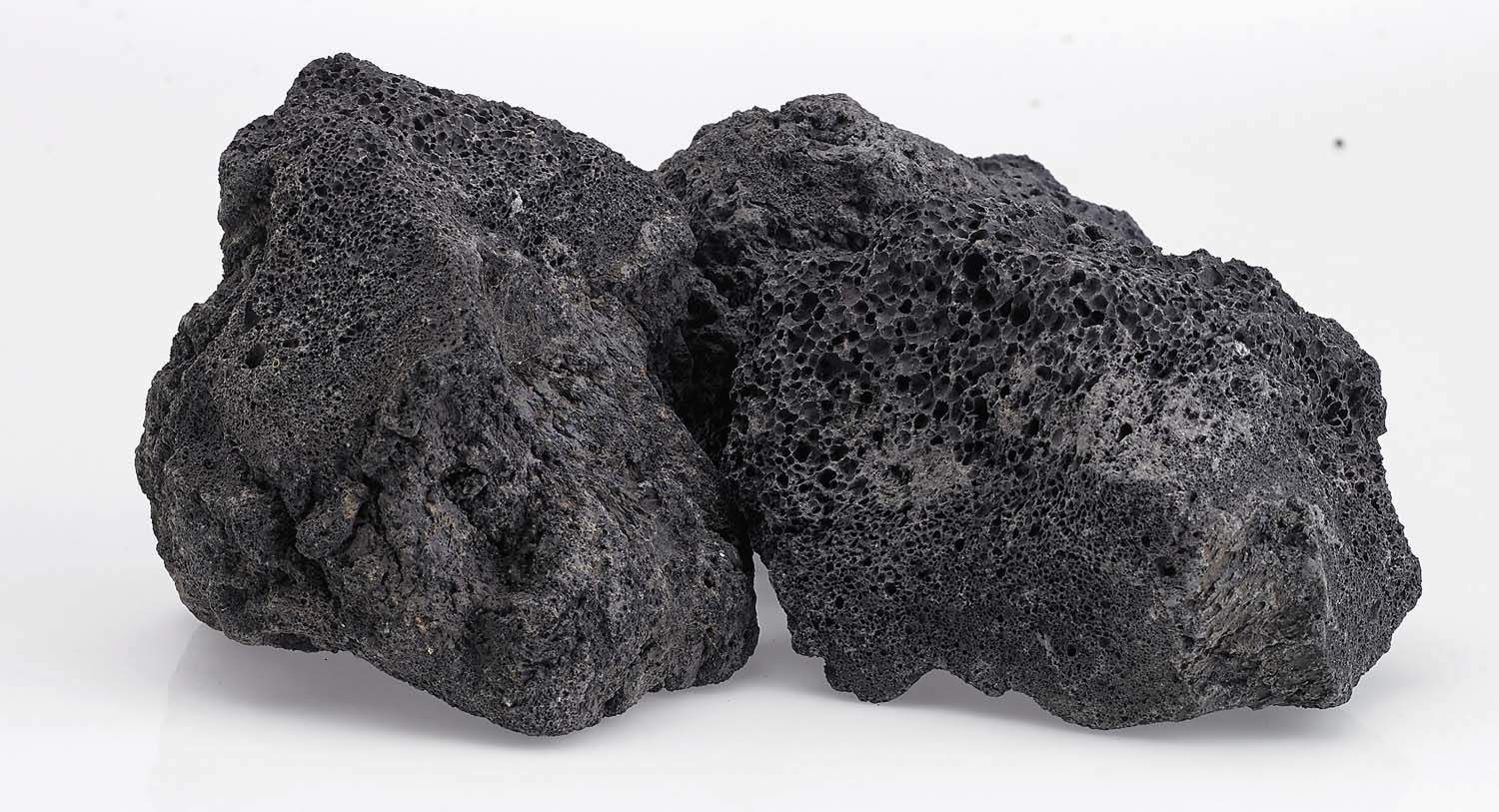 Black lava rock pieces with rugged porous faces, stacked in a small group