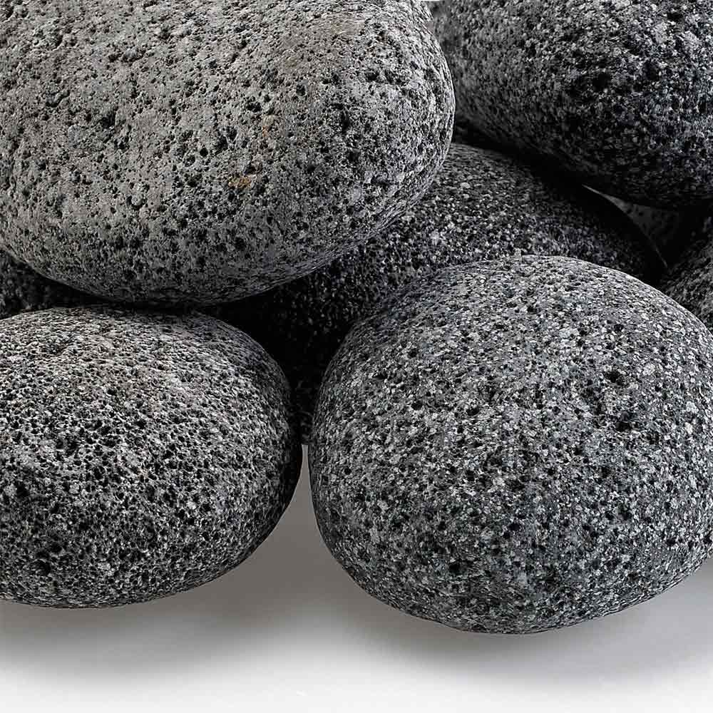 Gray lava stones close-up, speckled rough texture on smooth rounded rocks