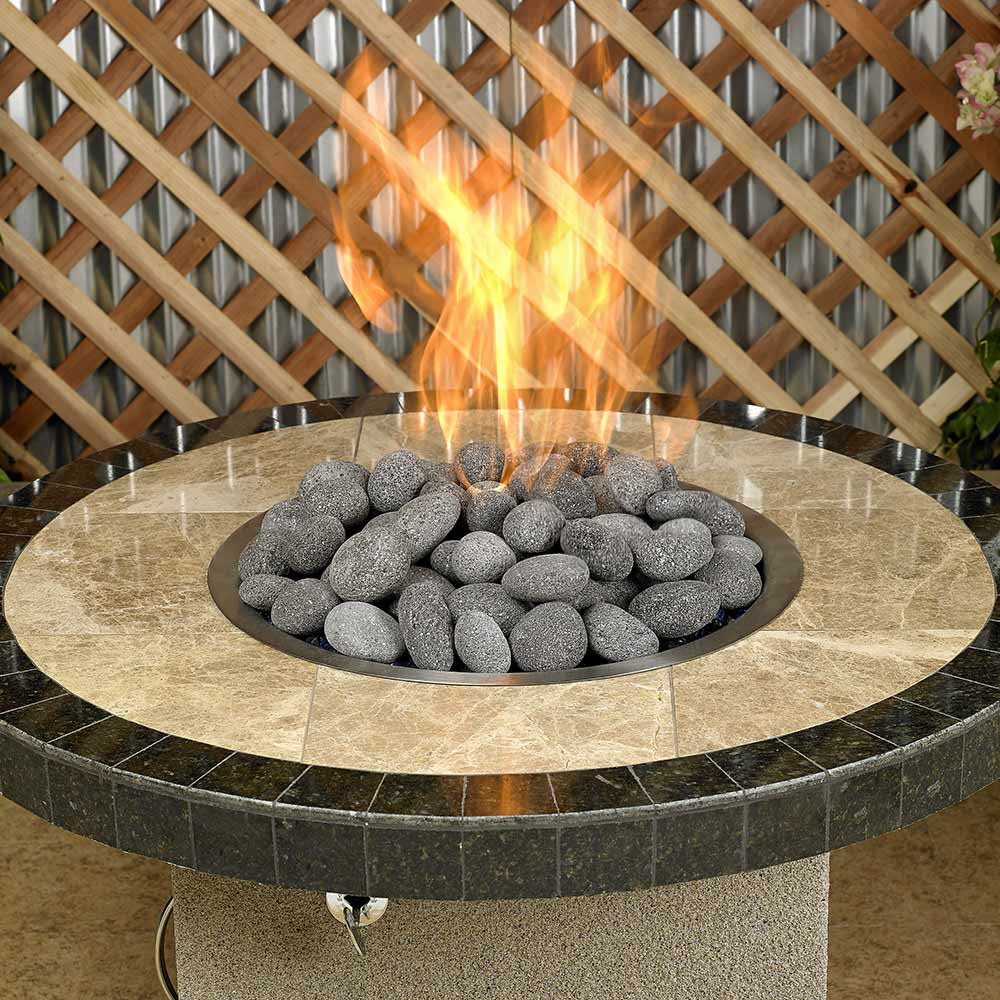 Gray lava stones in a round fire pit burner, smooth rounded rock pieces