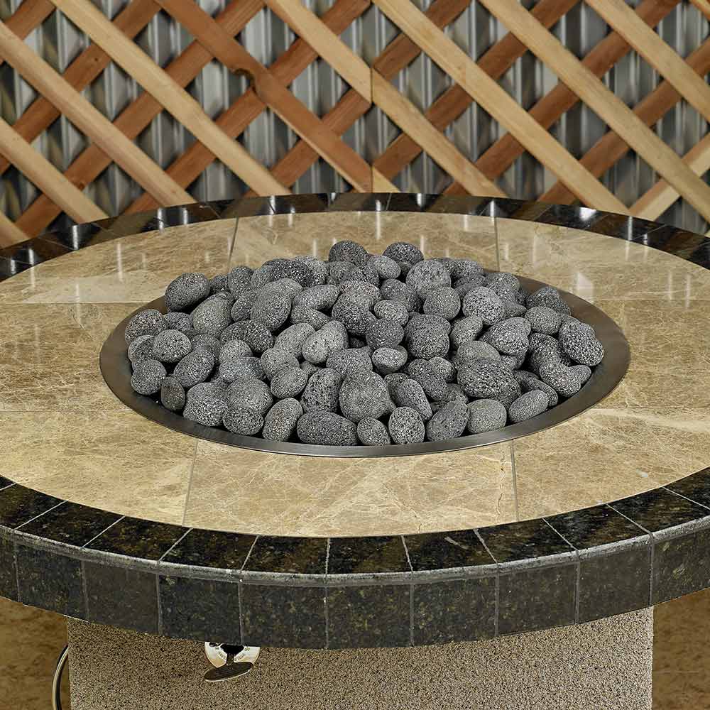 Fire pit insert filled with gray lava stones in a round metal tray