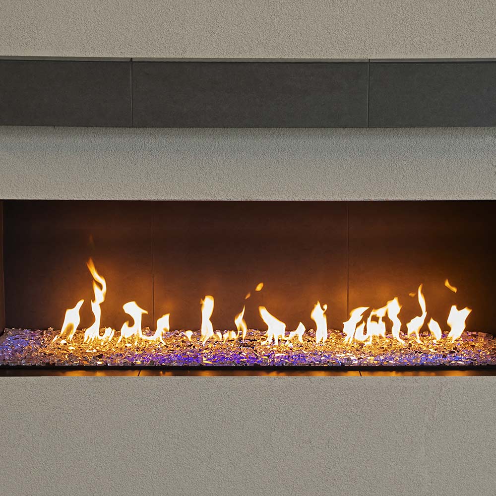 Built-in linear gas burner with flames and purple LED glow along glass bed