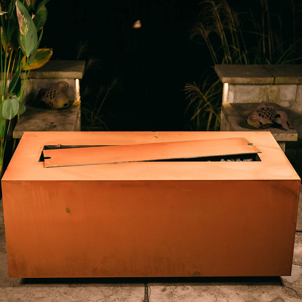 Linear gas fire pit with open burner tray and orange metal body
