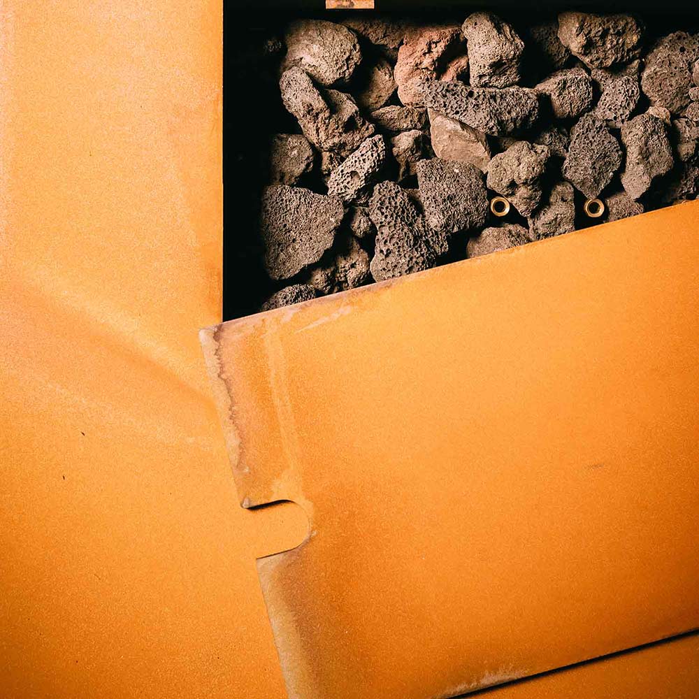 Side view of gas fire pit with burner rocks and metal edge