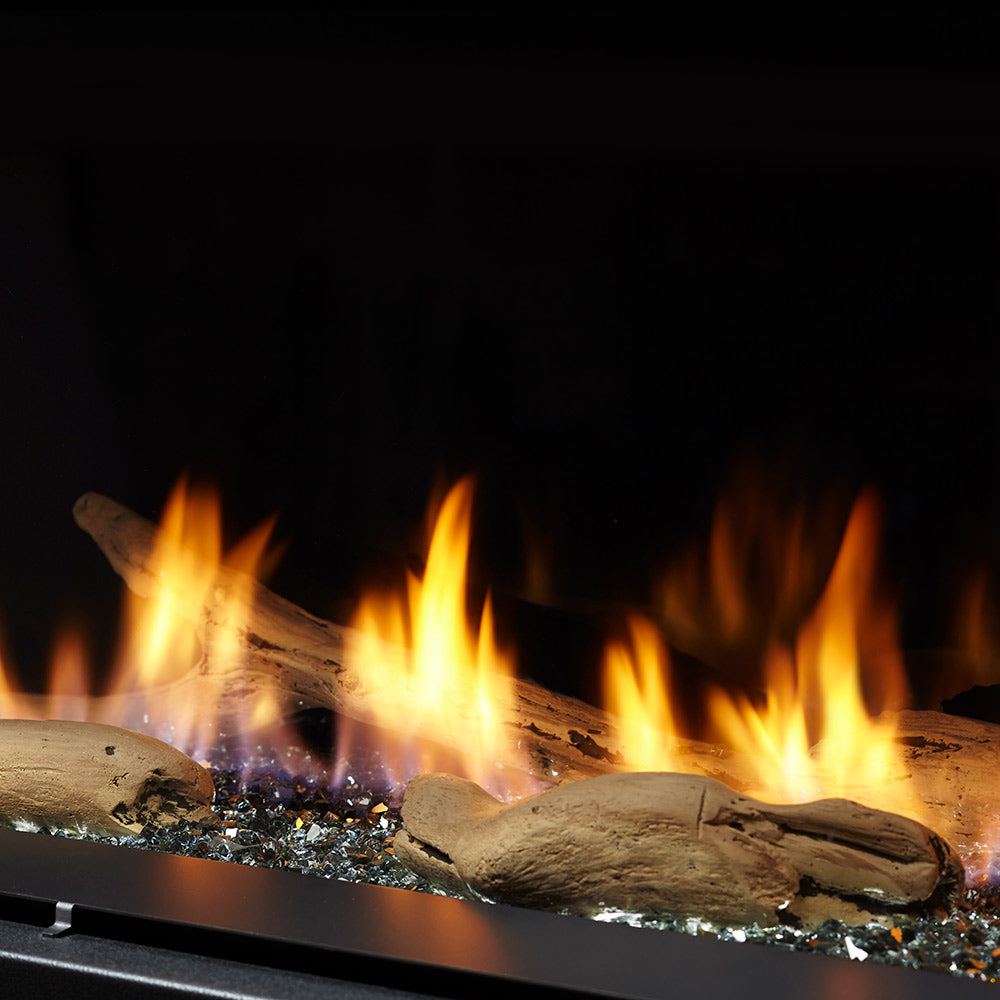 Driftwood log set with three burning logs in a fireplace firebed