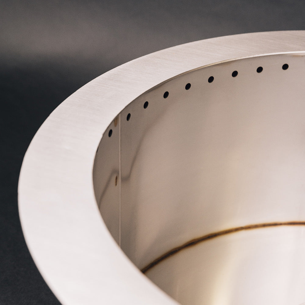 Round metal fire pit rim with evenly spaced vent holes inside view