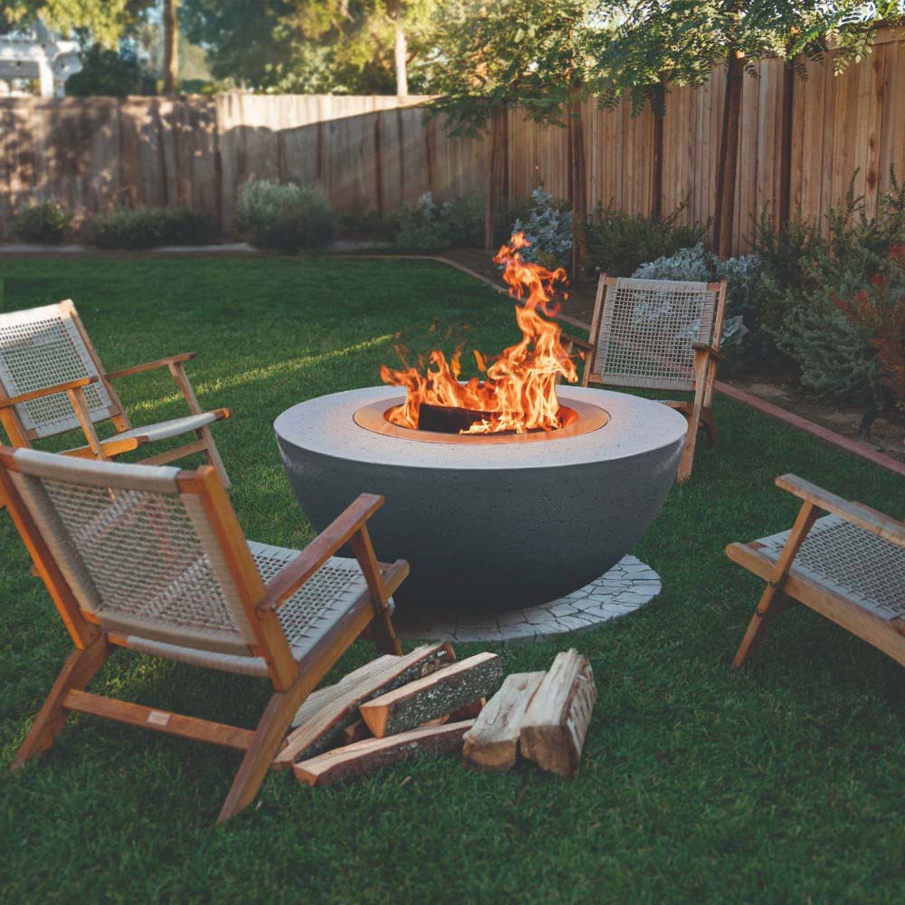 Dark GFRC wood fire bowl with visible flames in a round stainless steel insert