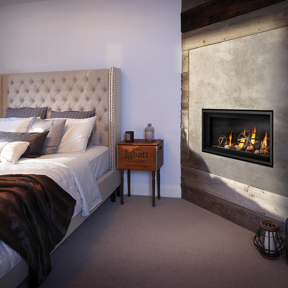 Inset gas fireplace with burning flames in a stone surround and black firebox trim