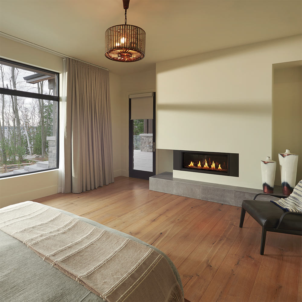 Wall-mounted gas fireplace with burning flames in a recessed niche and black frame