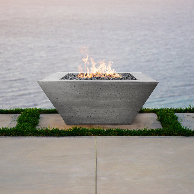 Concrete gas fire pit with open rectangular burner and flames, set on a patio base