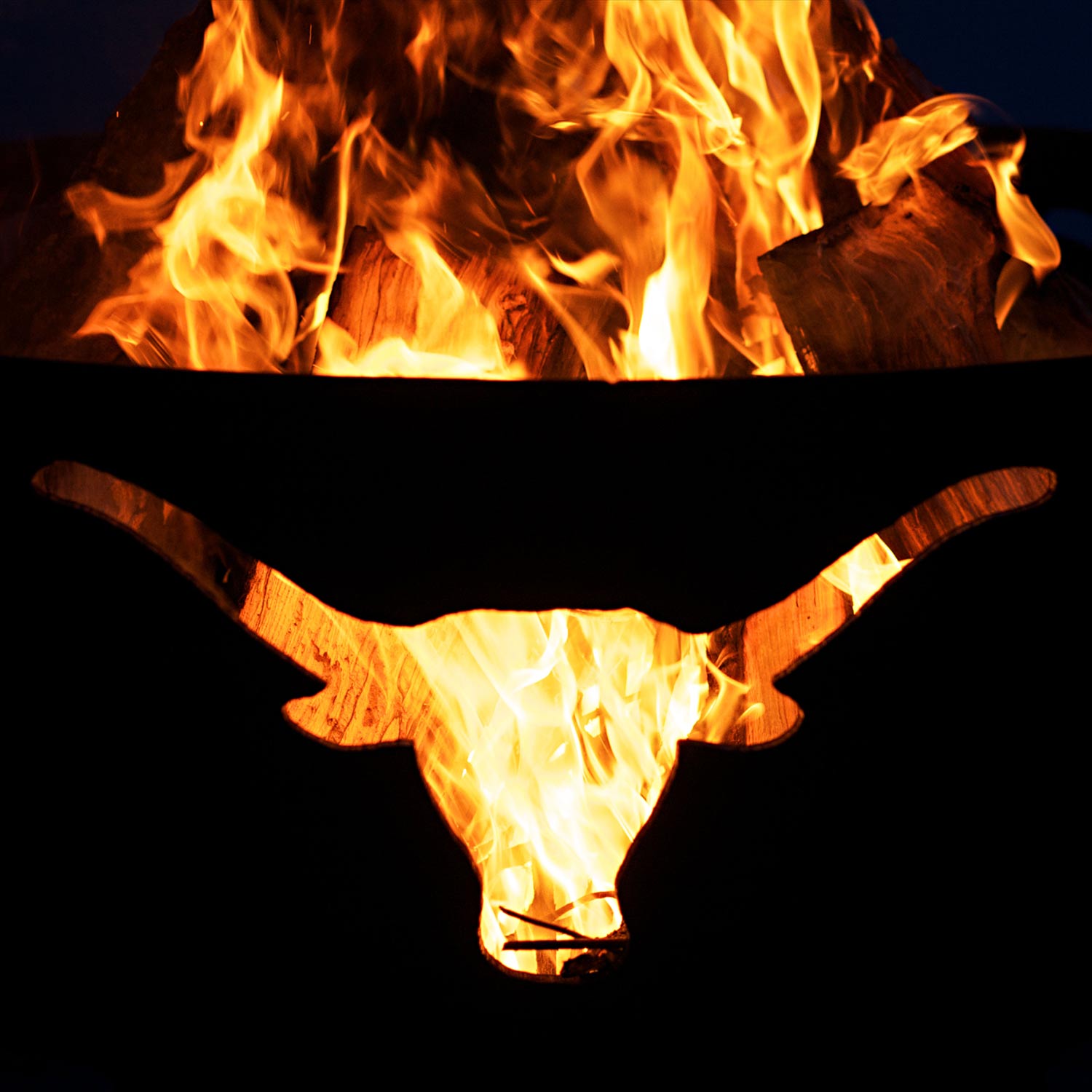 Close-up of flames burning in a gas fire pit bowl with longhorn cutout