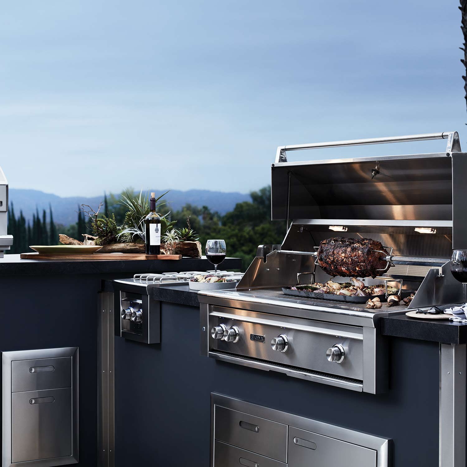 Built-in gas grill with open hood and grilling food on the cooking grates