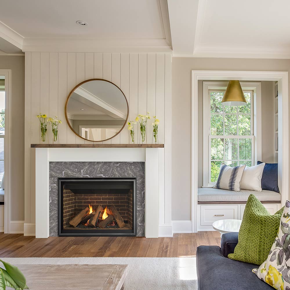 Black glass-front gas fireplace with burning logs set in a white mantel surround