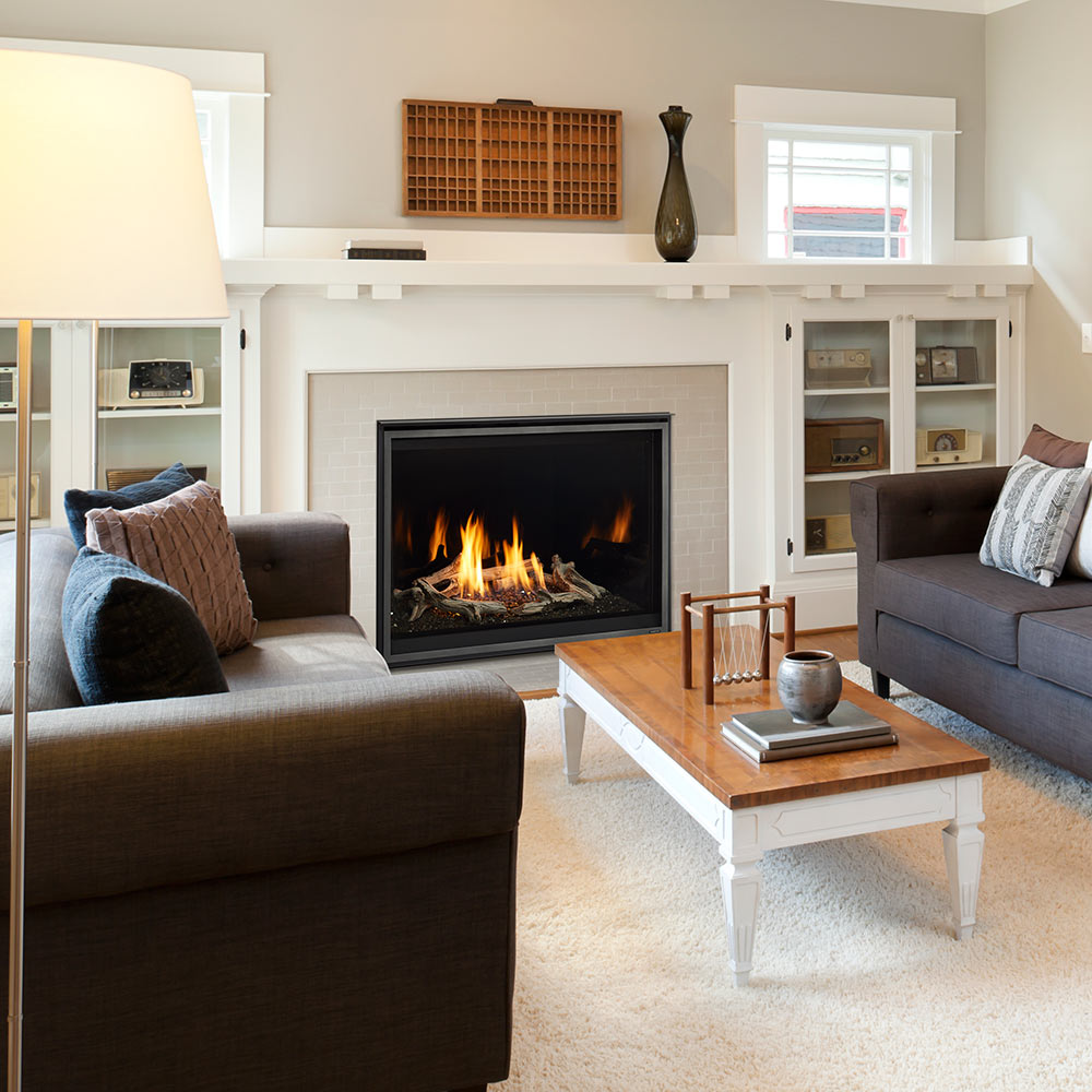 Modern black direct vent gas fireplace inset in a white living room with logs and flames