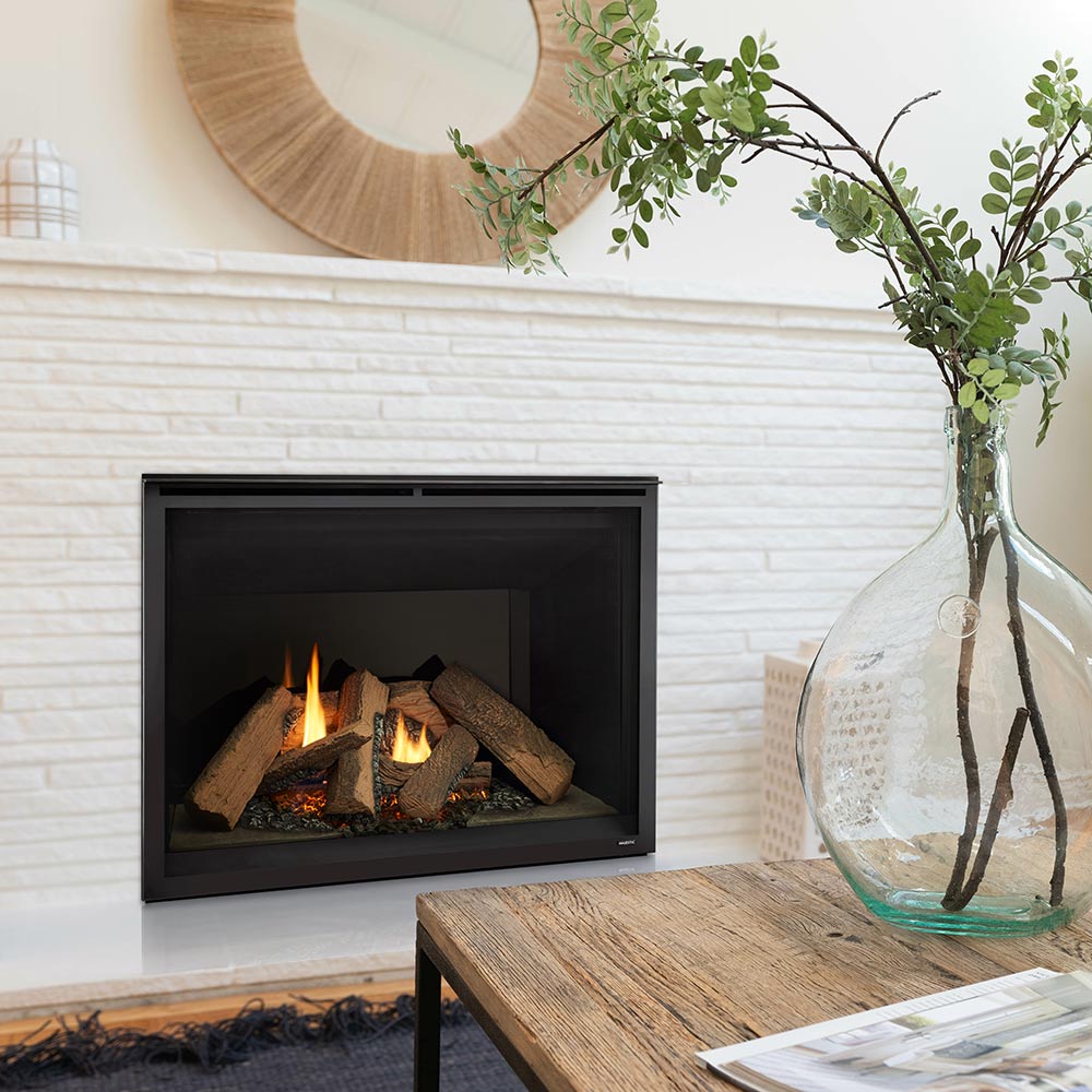 Black direct vent gas fireplace with glass front and glowing log fire in white room
