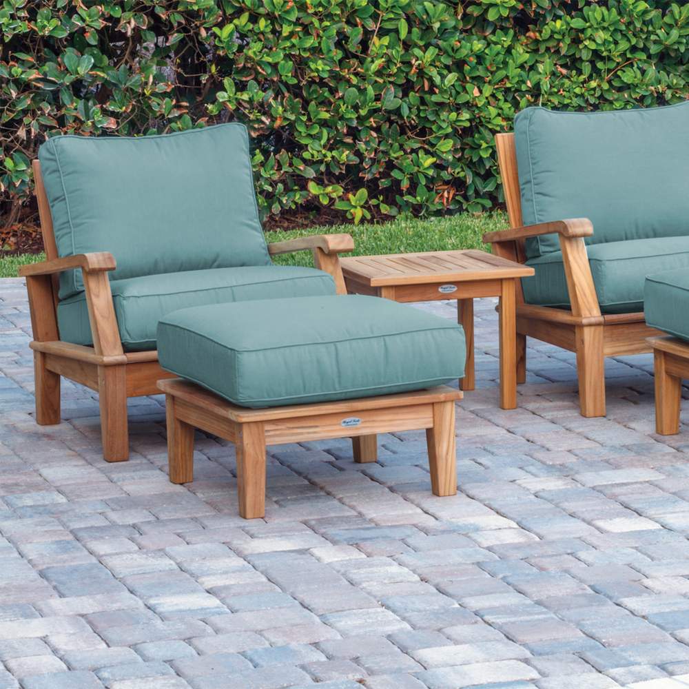 Teak outdoor lounge set with teal cushions and matching footstool
