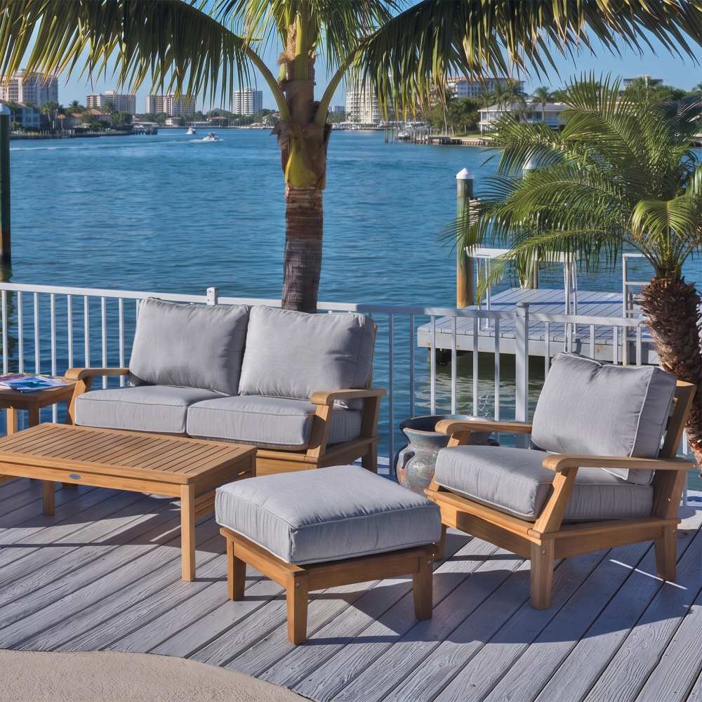 Teak outdoor seating set with light gray cushions and wooden coffee table