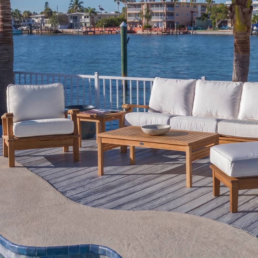 Teak outdoor seating set with white cushions and wooden coffee table