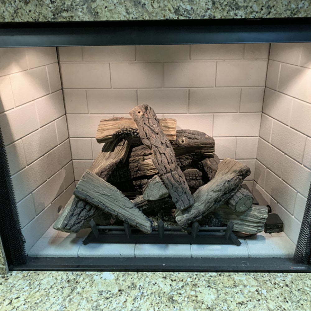 Fireplace firebox with decorative logs and firewood-style pieces