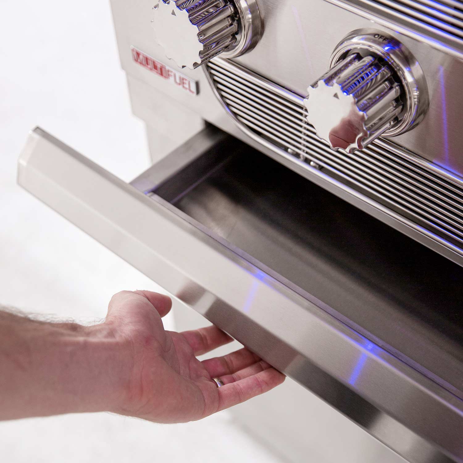 Stainless grill drawer or storage panel with hand pulling a front handle.