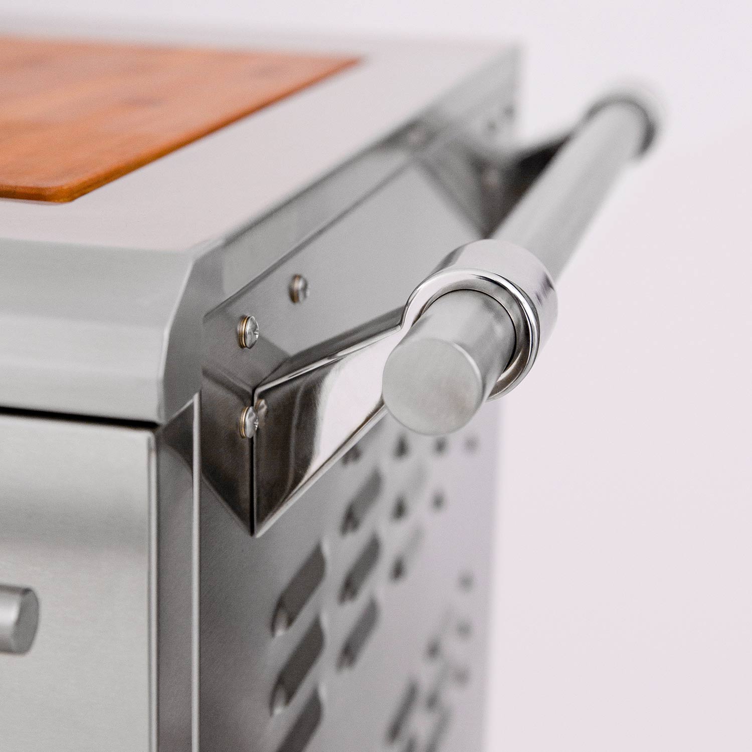 Stainless grill control knob and front panel with perforated side chute details.