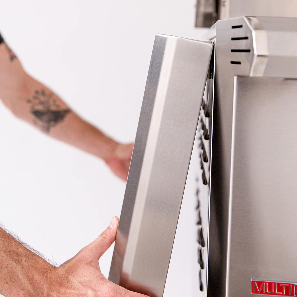 Person installing a side panel or access cover on the grill cart.