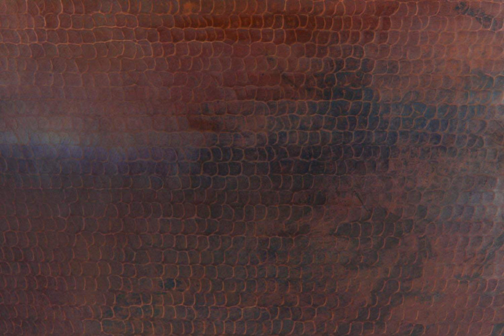 Hammered copper fire bowl wall texture with mottled finish