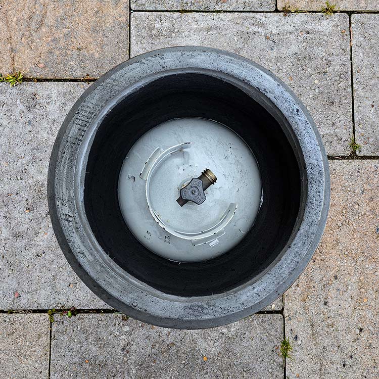 Concrete propane enclosure opening with light interior and propane valve connection