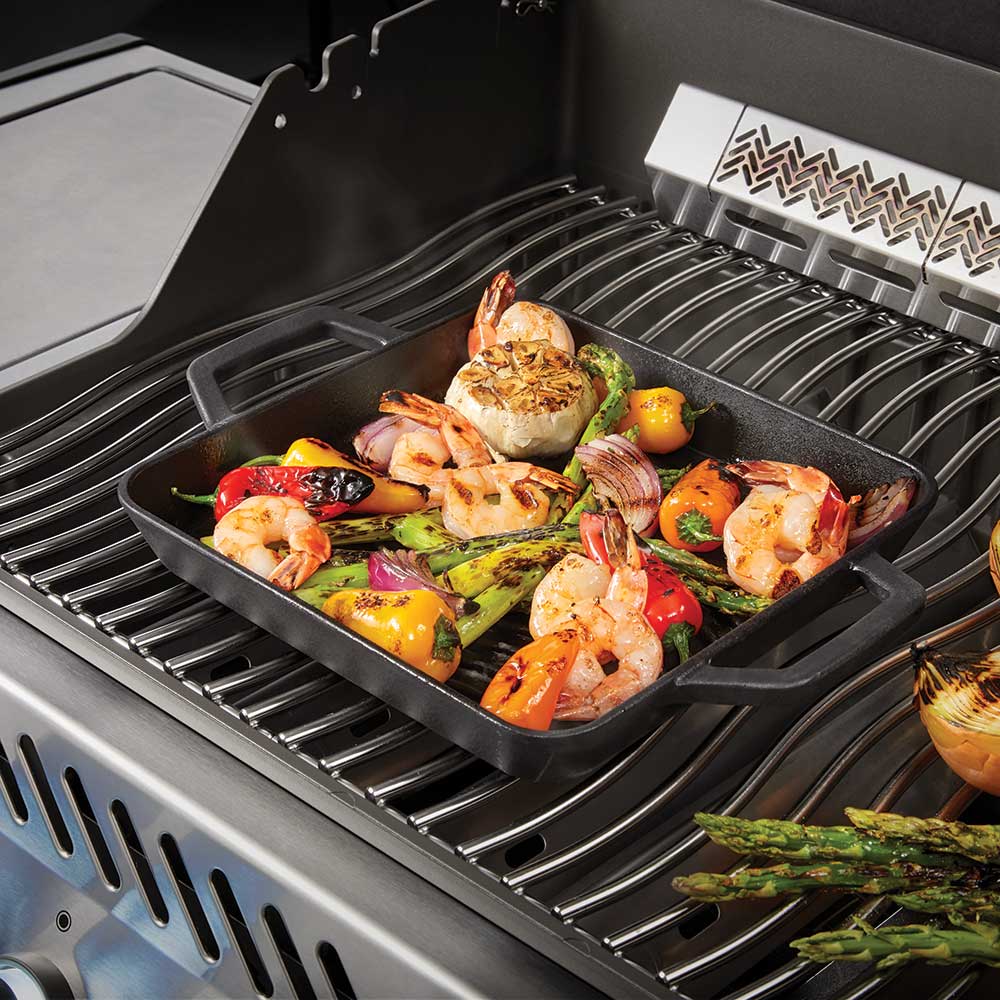 Square cast iron griddle grilling shrimp, vegetables, and peppers
