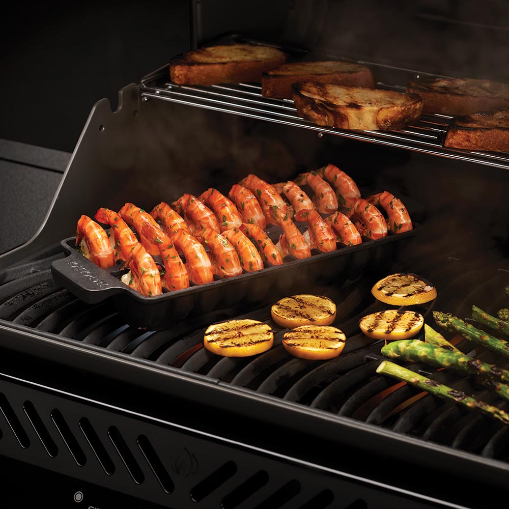 Jumbo shrimp tray on grill with grilled shrimp and sliced vegetables