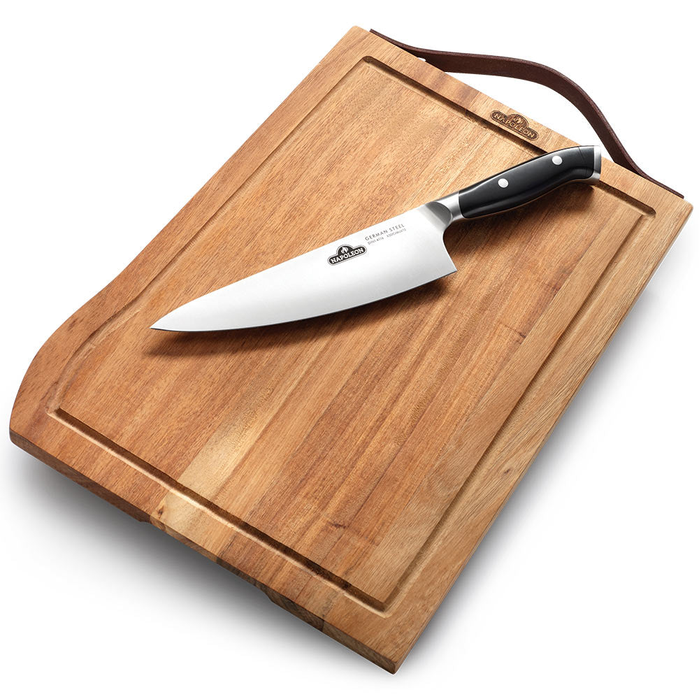 Wood cutting board with chef knife, knife resting on board