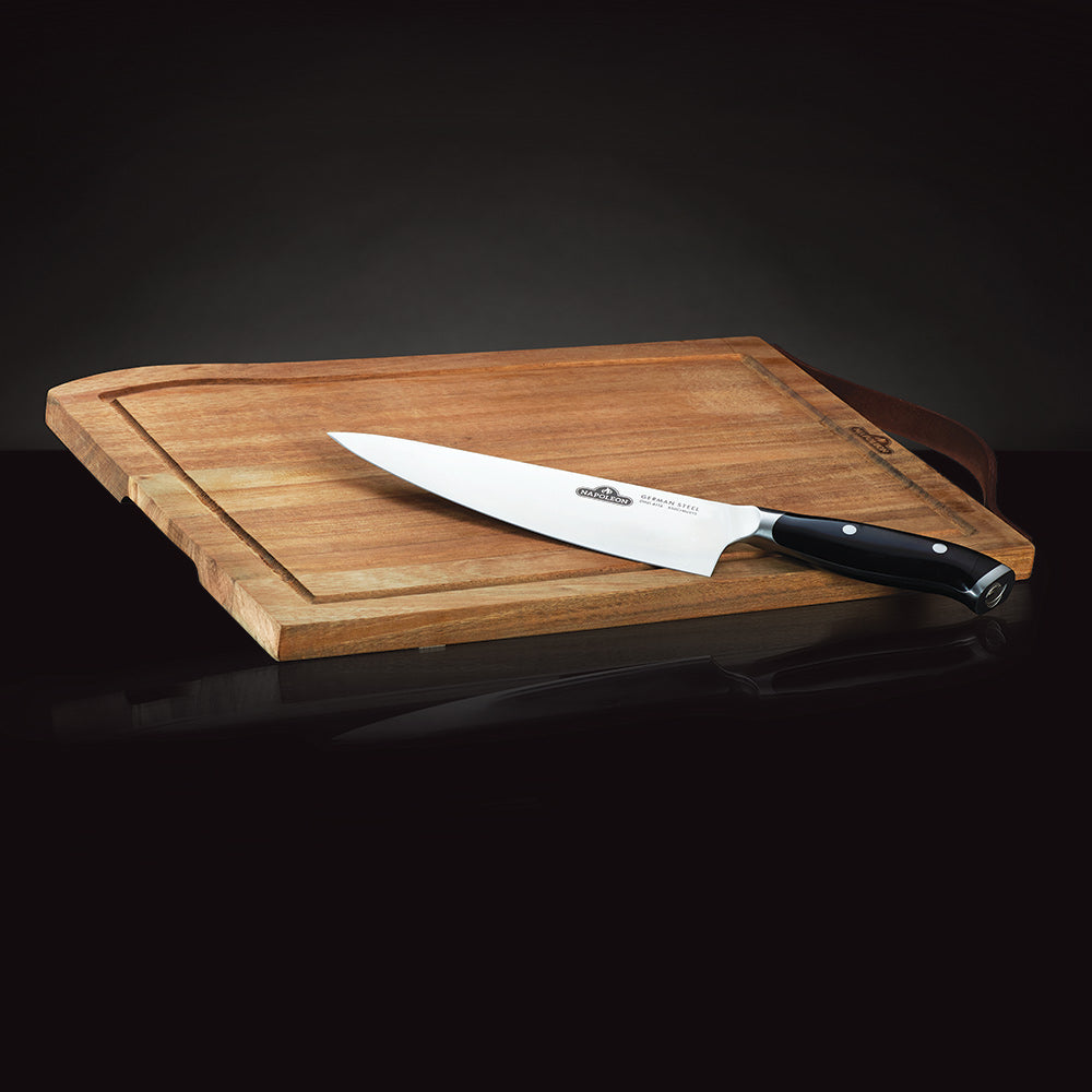 Wood cutting board with chef knife resting diagonally
