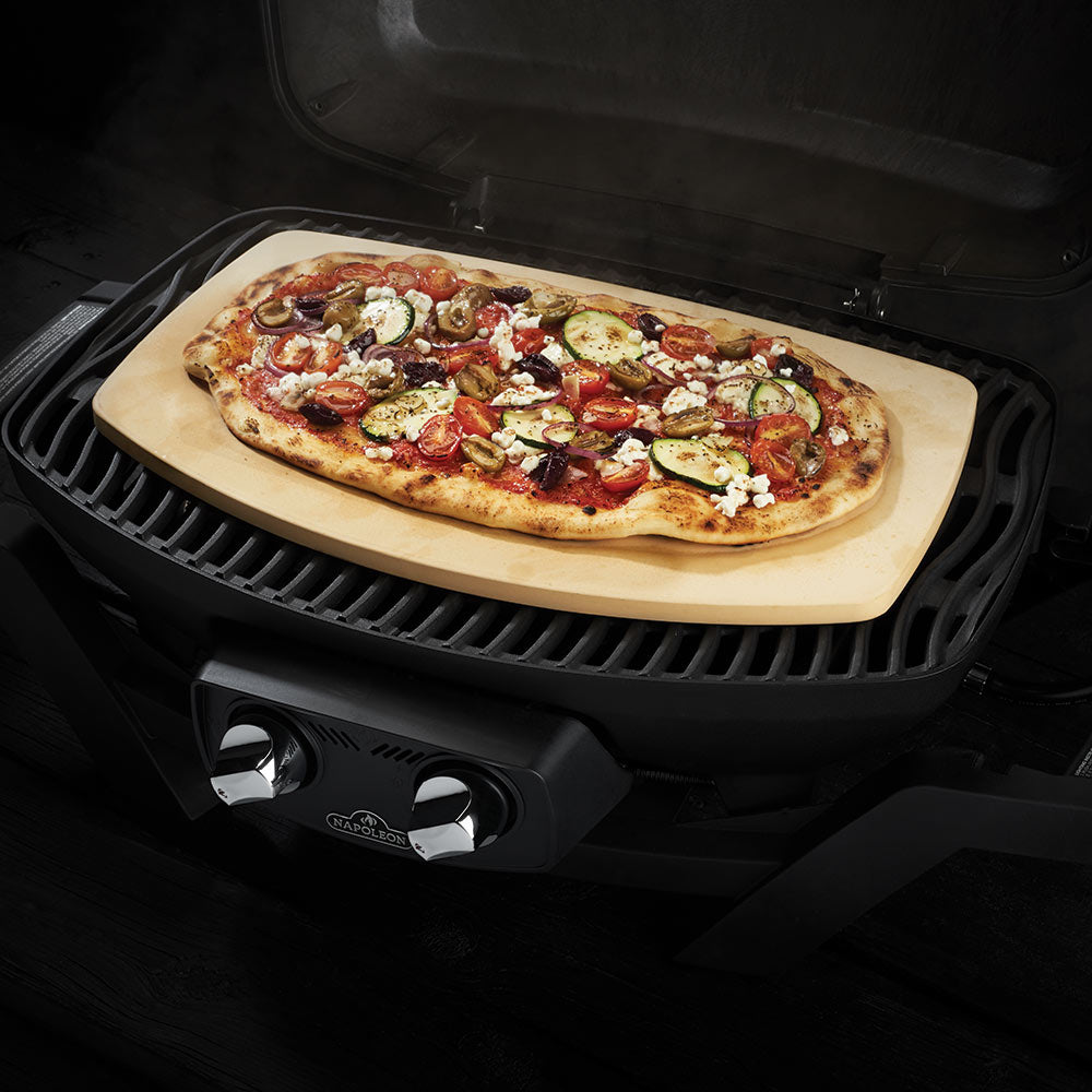 Pizza on beige Napoleon pizza stone inside a grill