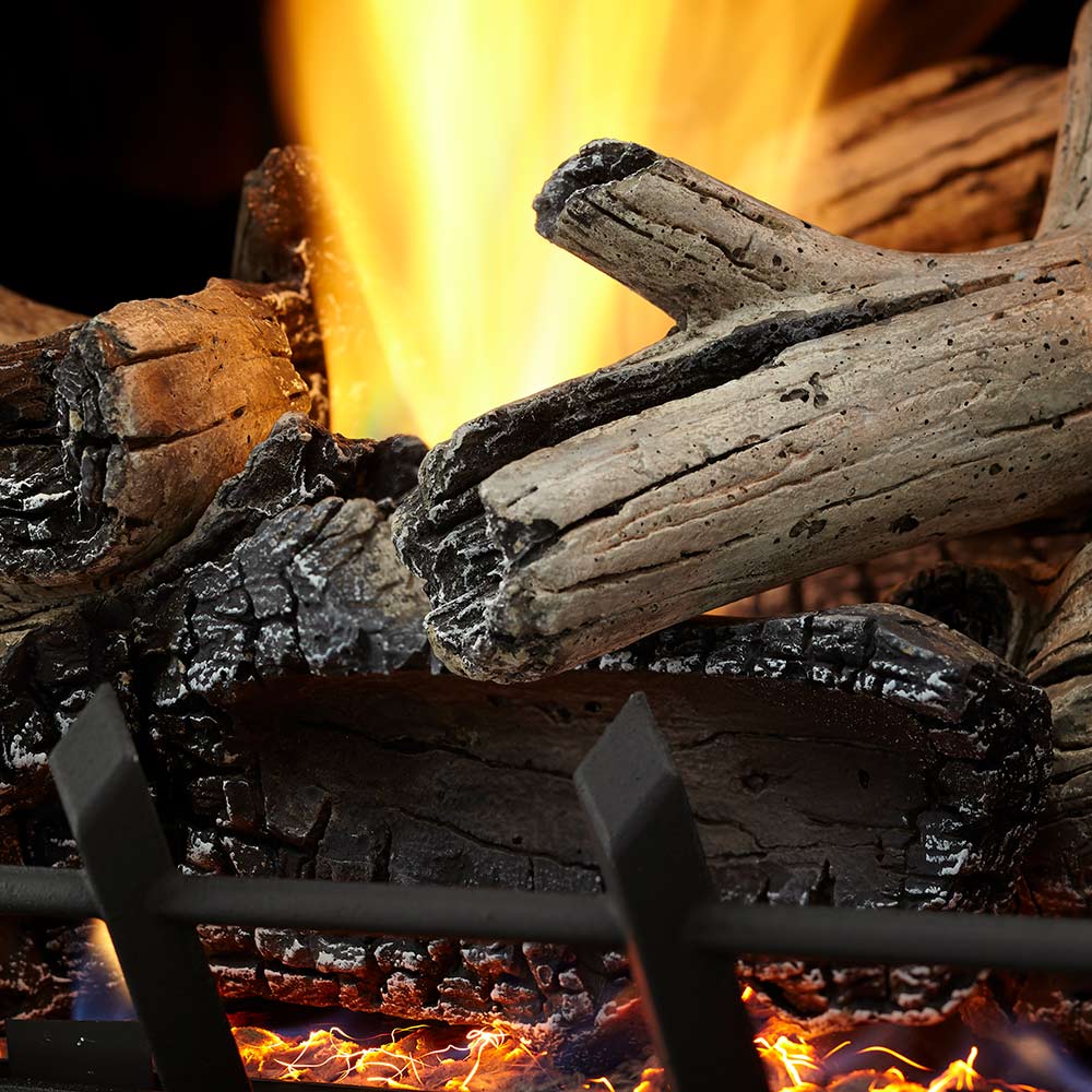 Close-up of vent-free gas logs with yellow flames rising above a dark fuel bed