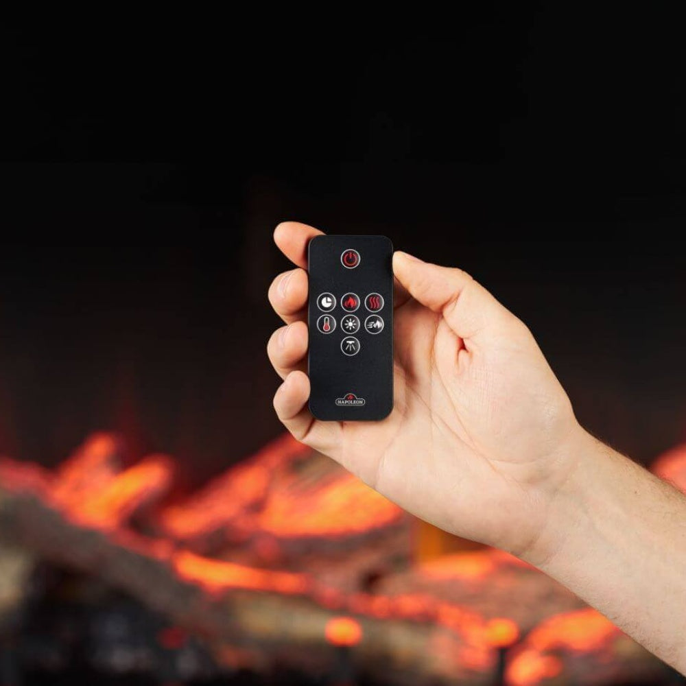 Electric fireplace remote control held in front of the glowing fire display