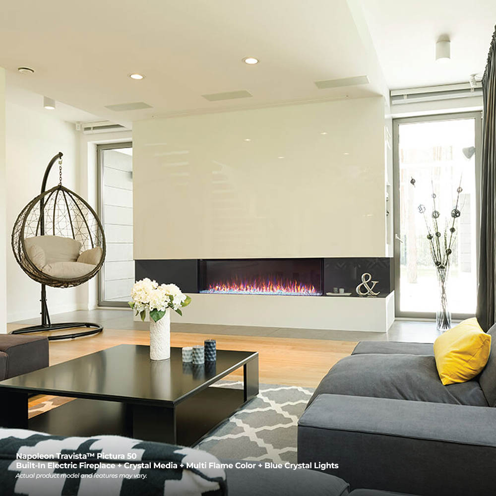 Wall-mounted electric fireplace with black insert and blue flame glow over crystal media