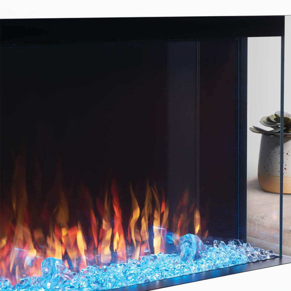 Trivista electric fireplace with glass side panel and orange flames over blue crystals
