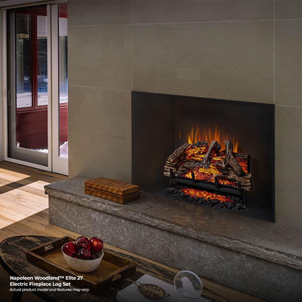 Electric fireplace log set with gray logs and orange flame glow in a wall niche