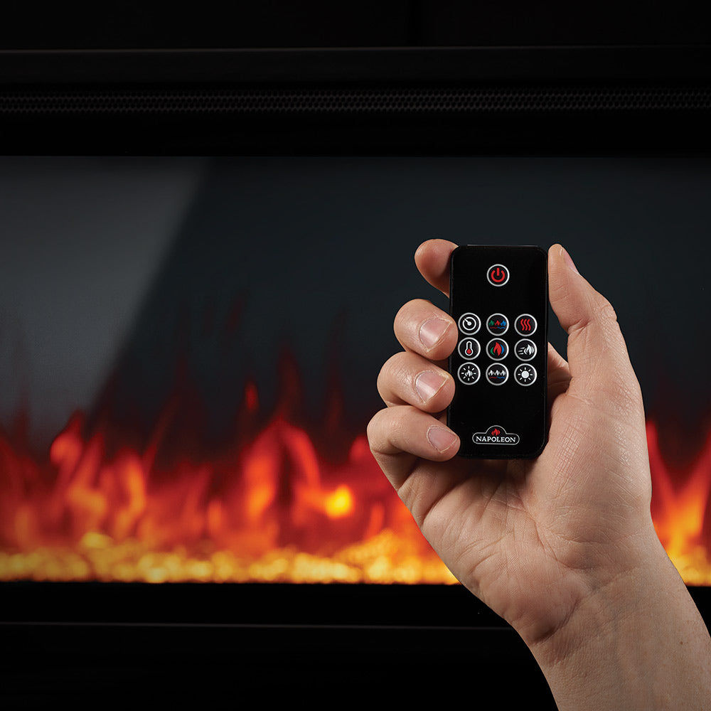Electric fireplace remote control in hand with glowing flame and power buttons.