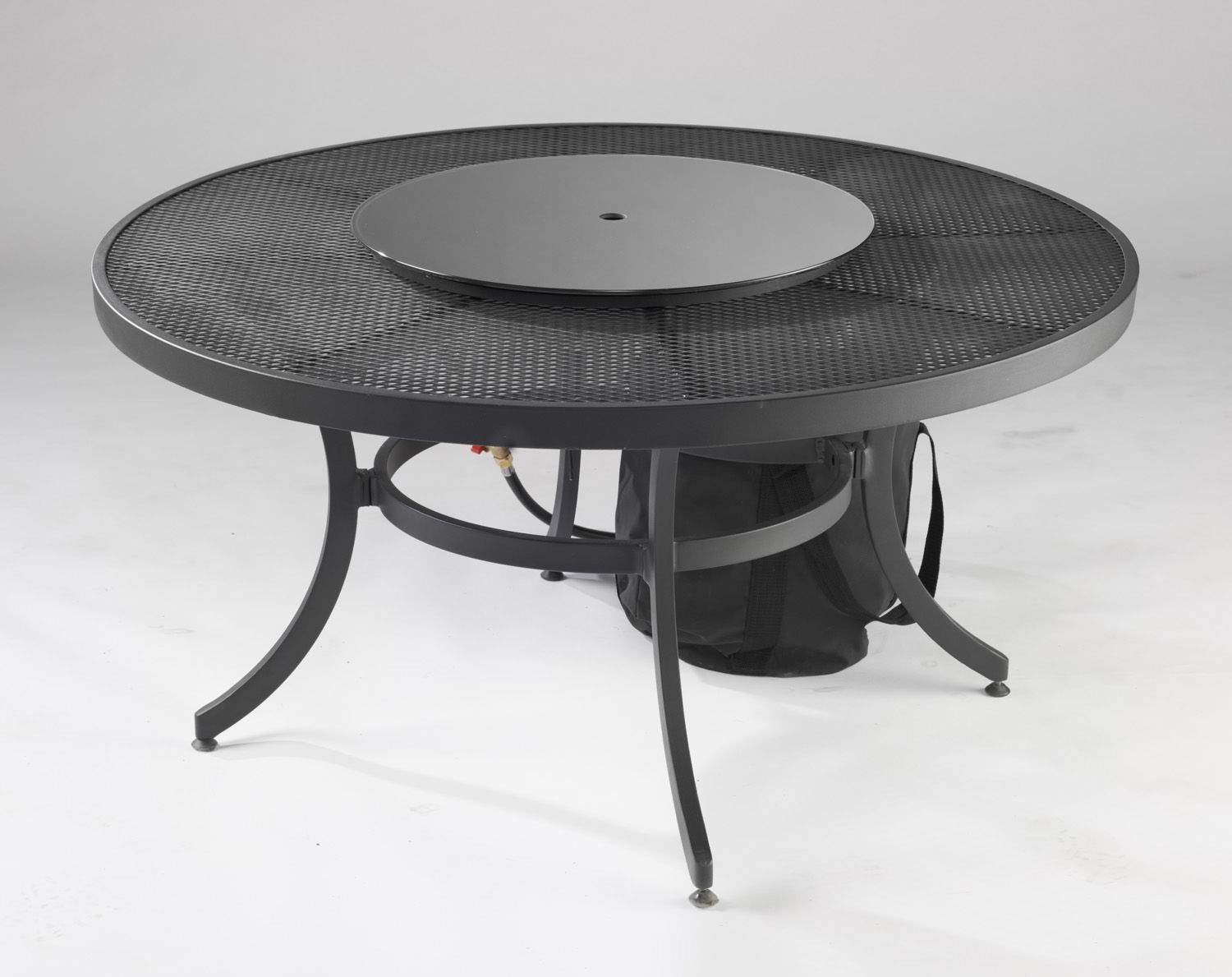 Black round glass burner cover on patio fire table with center opening